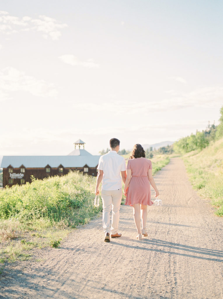 a man and woman walk towards Hillside winery in Naramata 