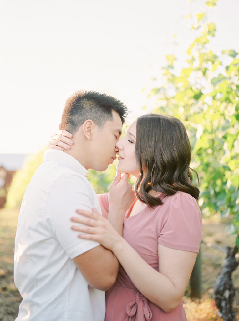 a man kisses his fiancé at Hillside Winery in Naramata 