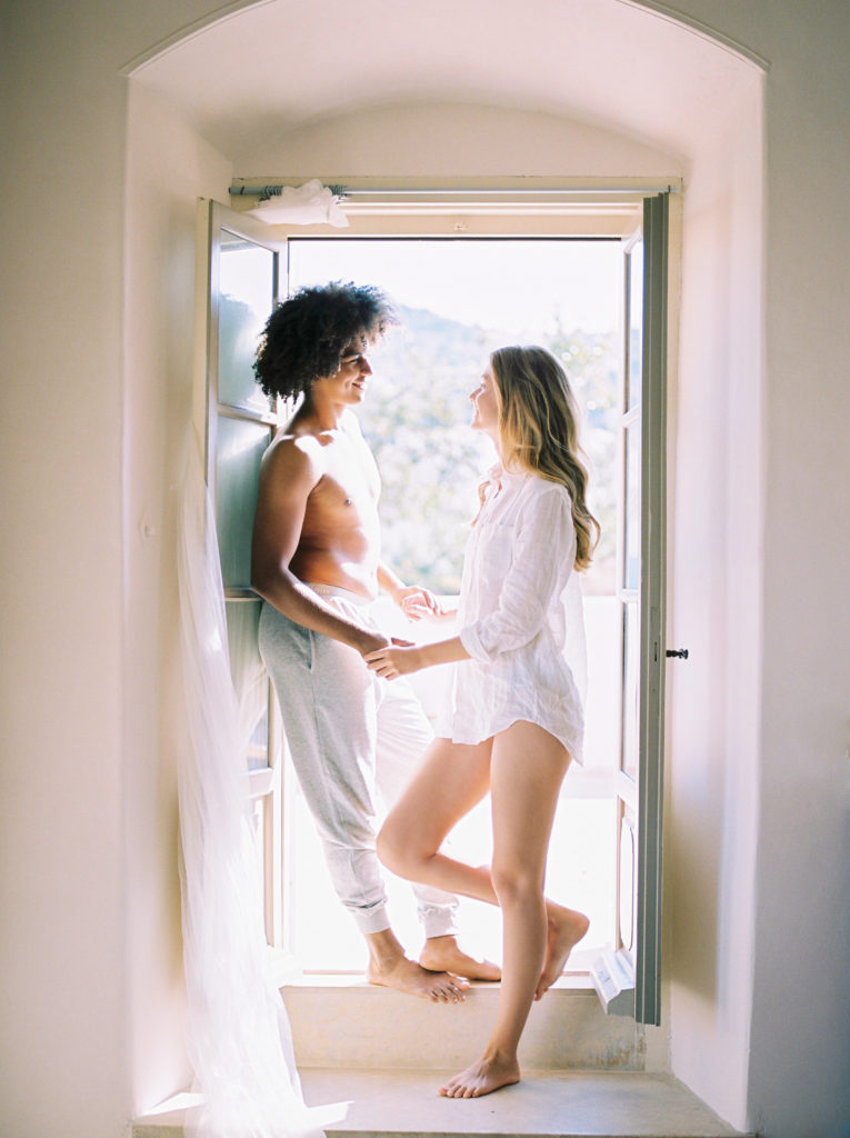 a couple poses in a window of their Kelowna honeymoon villa 
