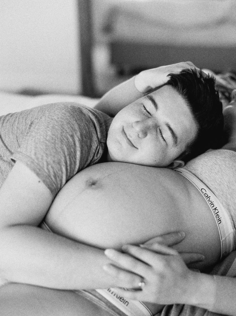 dad to be resting his head on baby bump in their Kelowna home 