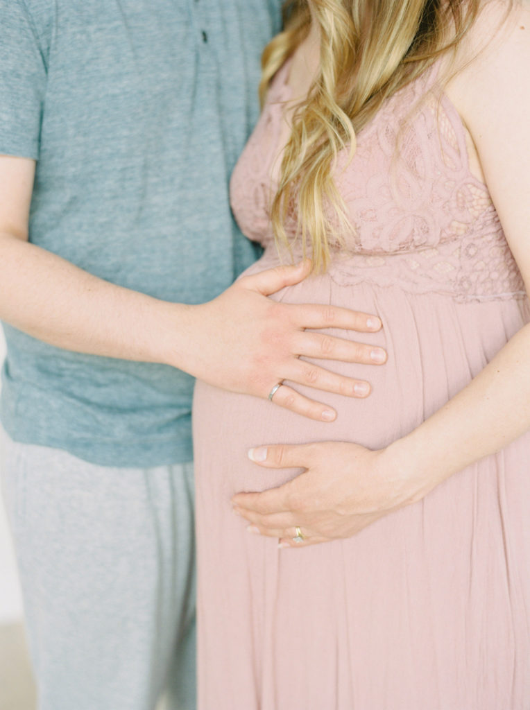 hands on pregnant tummy in pink dress 