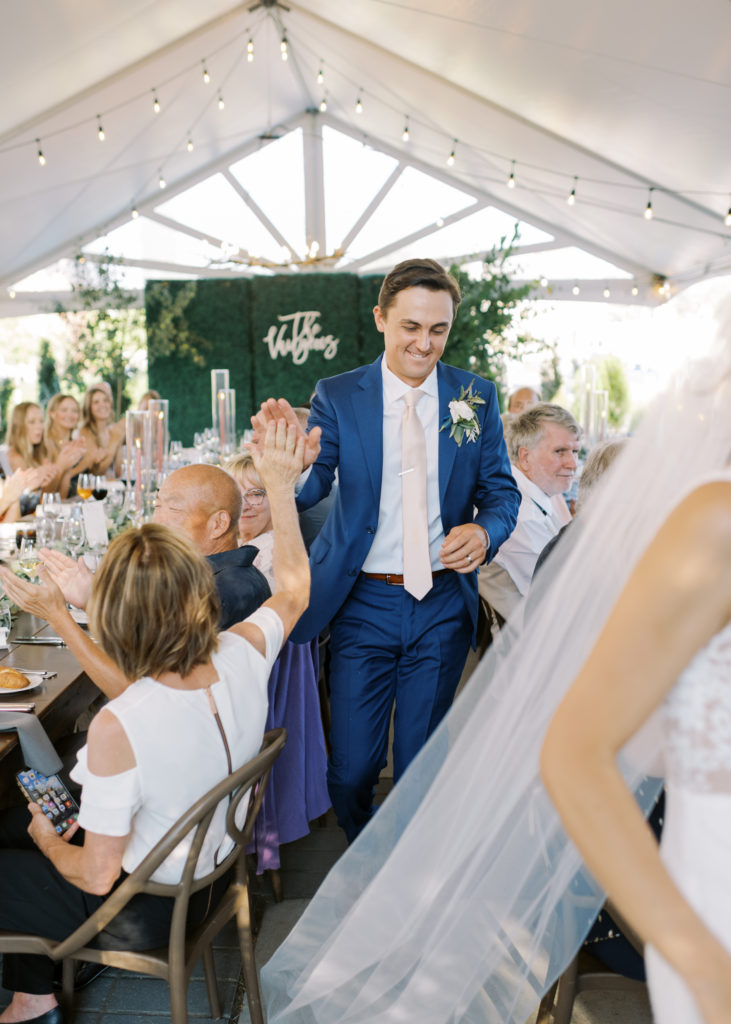a groom enters his Kelowna tented wedding reception 