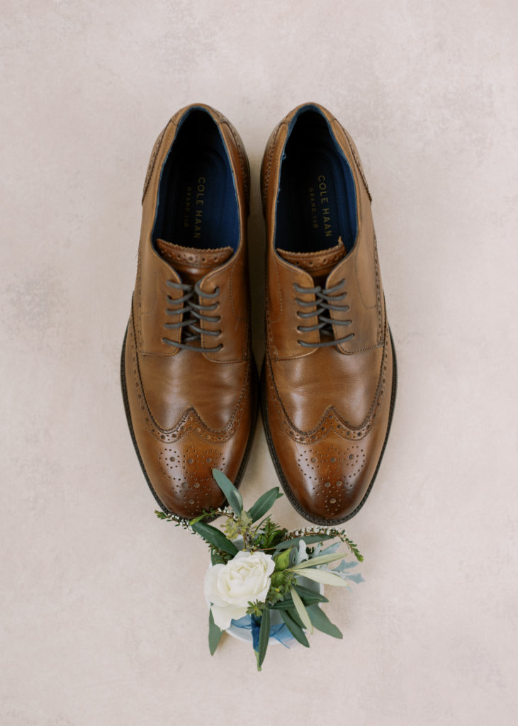 brown leather groom shoes with his boutonnière 