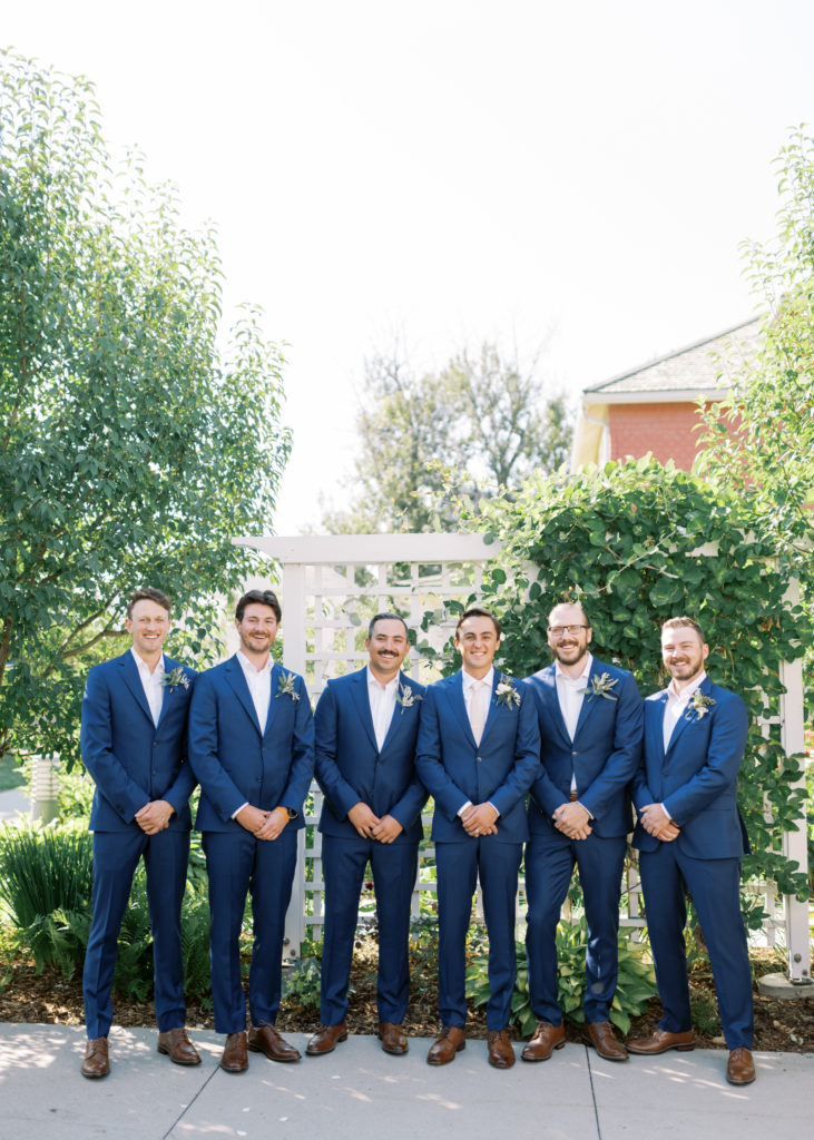 groomsmen in blue suits posing for a wedding photo 