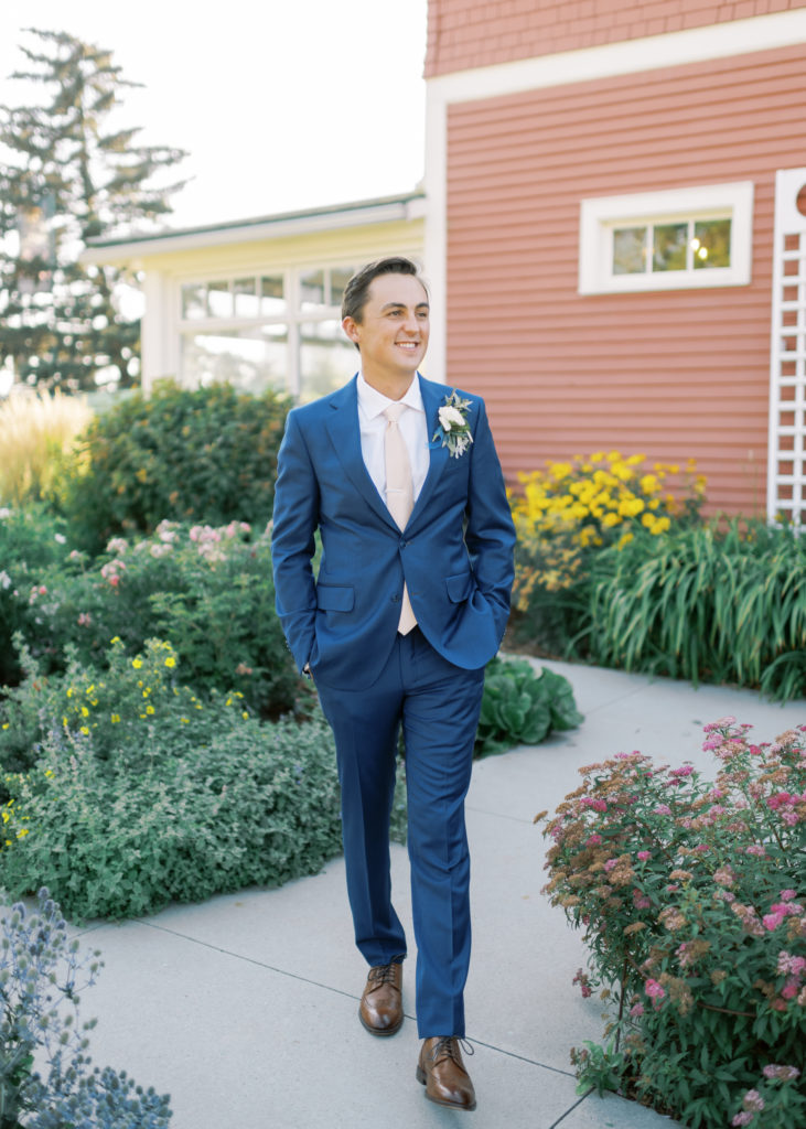 a groom walking through a Kelowna garden 