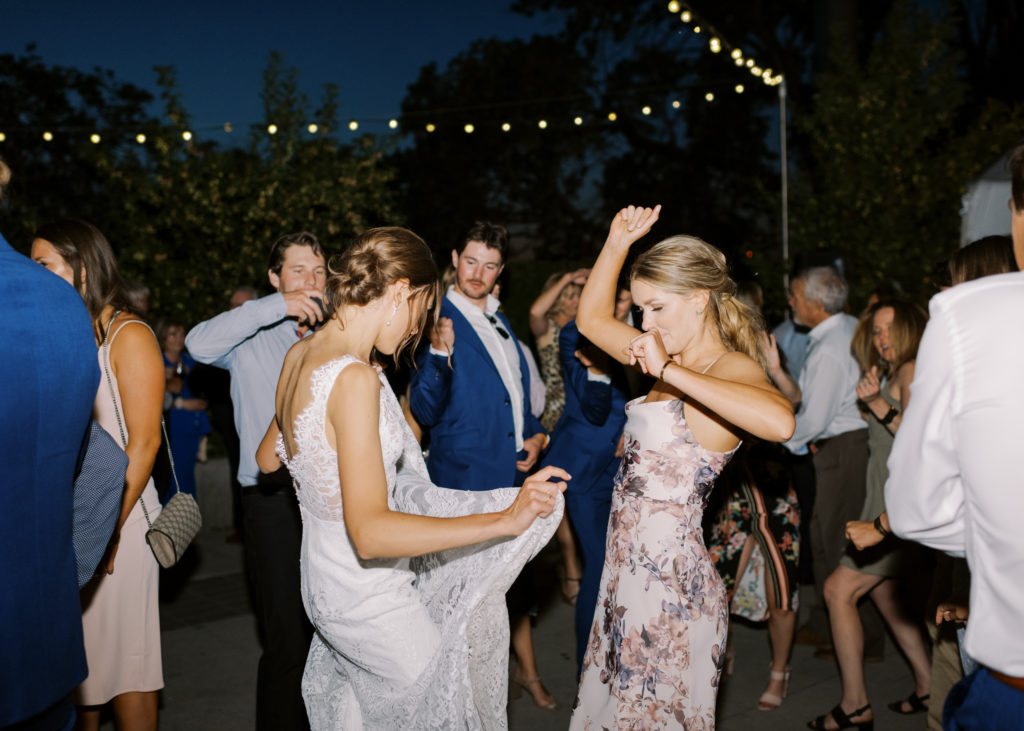 a wedding party dances outdoors at night 