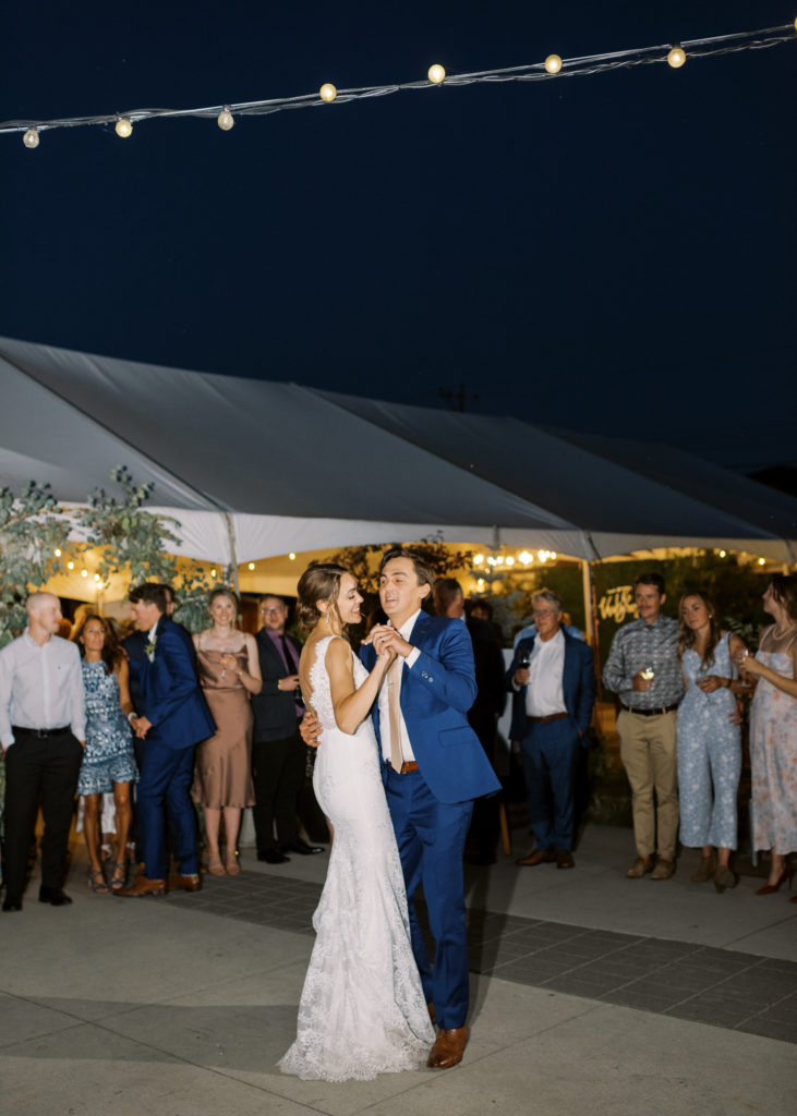 a bride and groom have their first dance outdoors 