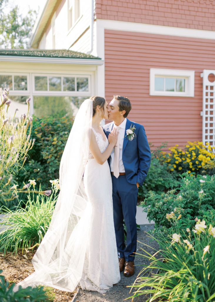 a bride and groom kiss in a garden at their Kelowna tented wedding  