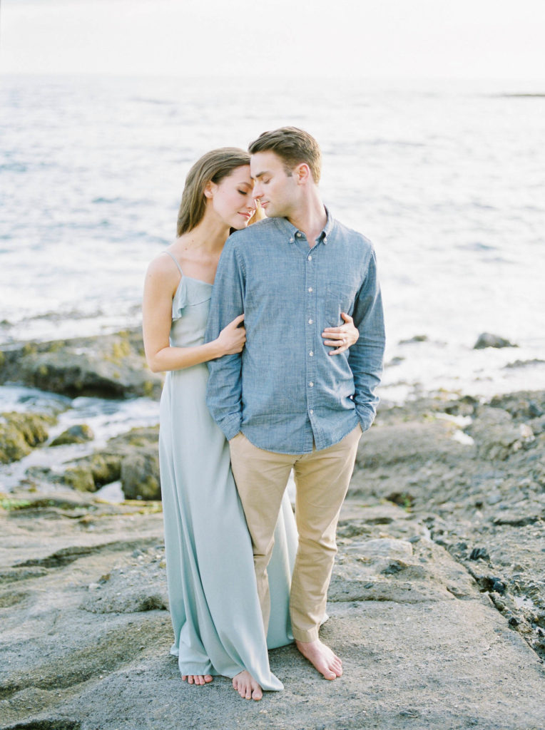 an engaged couple dressed in blue on Vancouver beach 