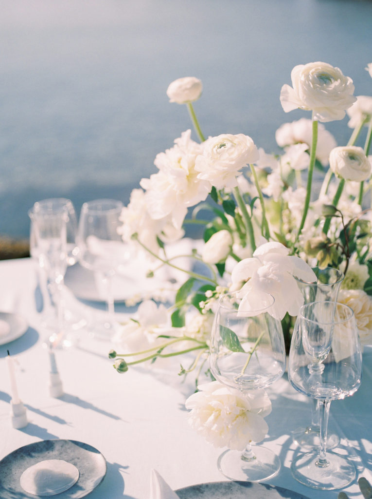 a romantic white floral centrepiece for an outdoor beach wedding reception.