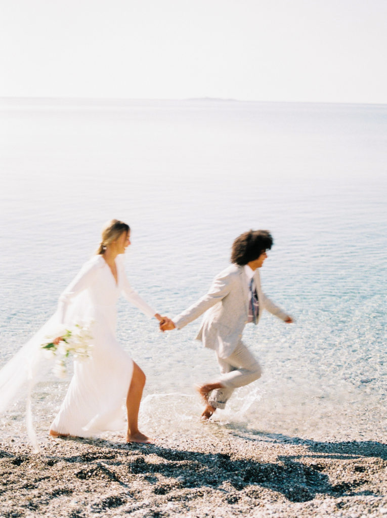 a bride and groom running through the water at their Vancouver beach wedding 