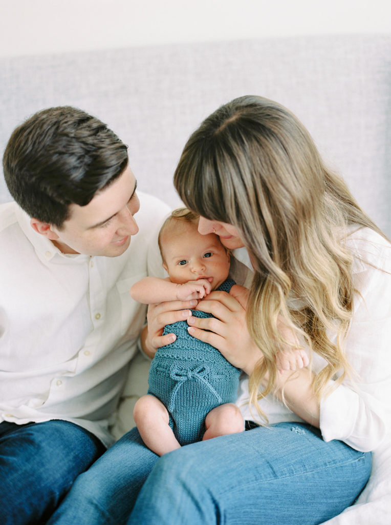 mom and dad play with baby for Kelowna in home newborn session 