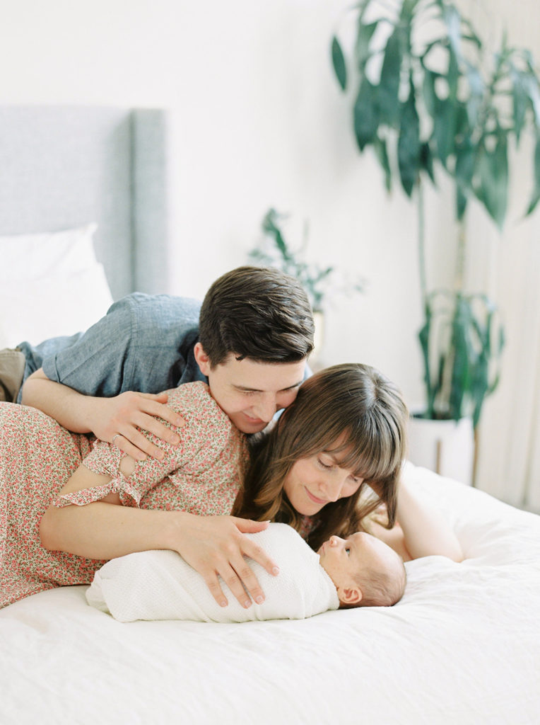 mom and dad admire baby at Kelowna in home newborn session 