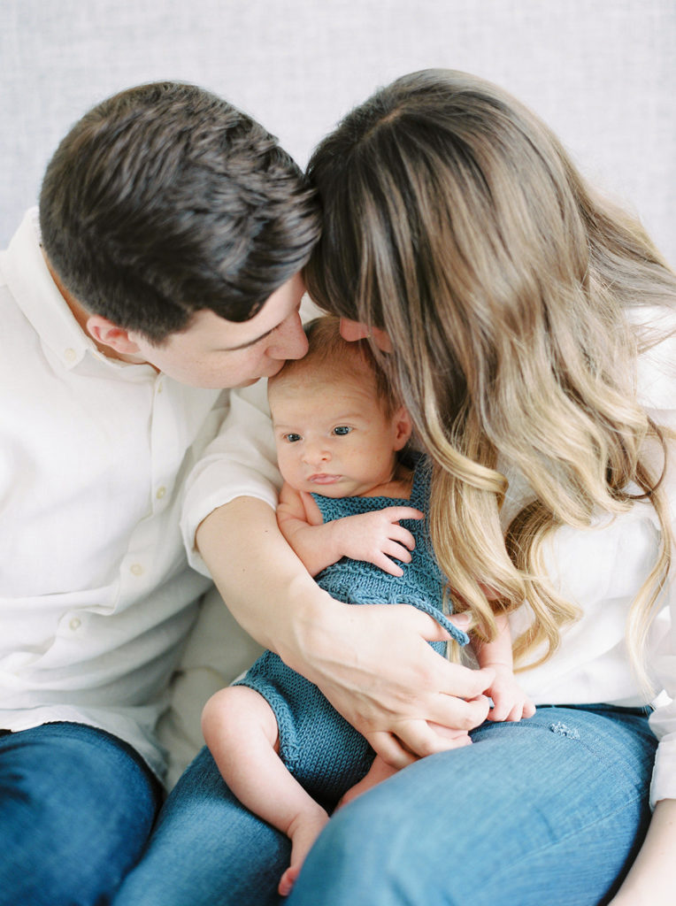 mom and dad kiss son for Kelowna in home newborn session 
