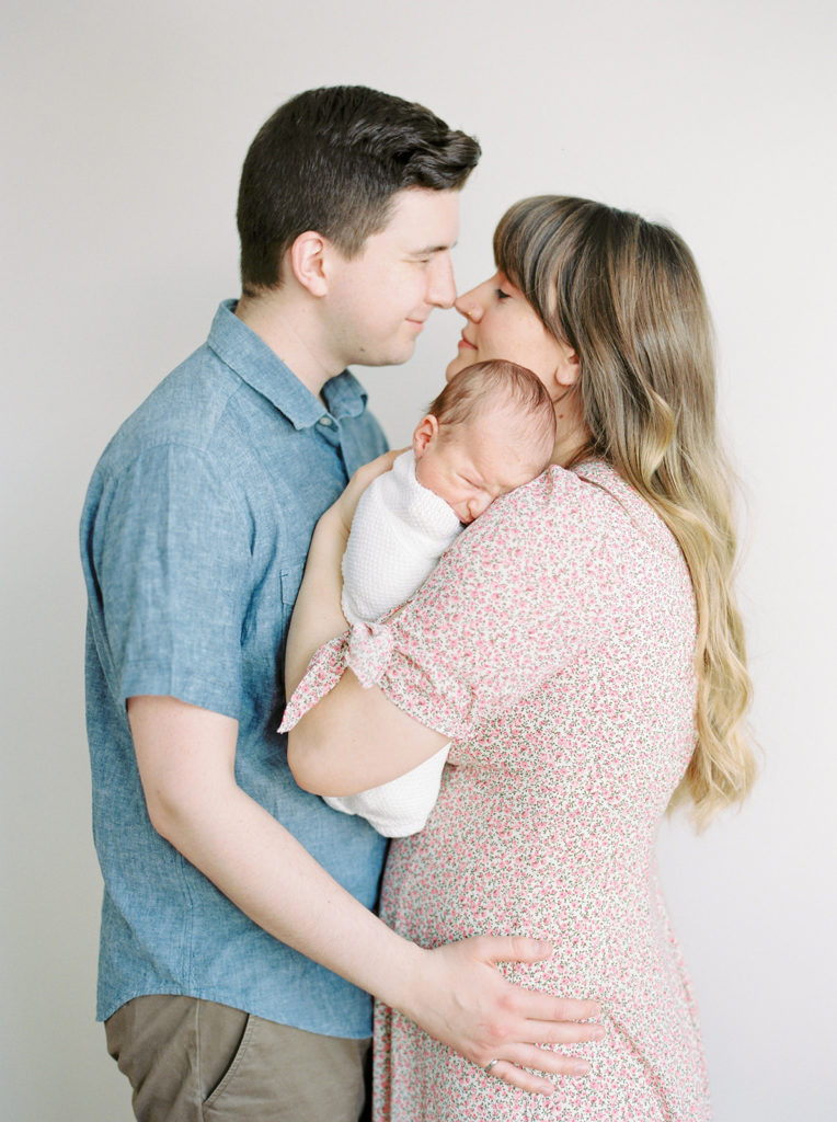 mom and dad pose with baby for Kelowna in home newborn session 