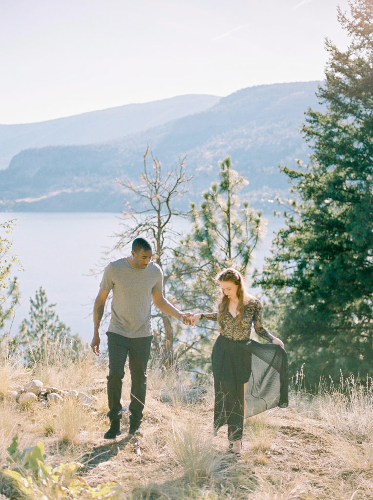 a bride and groom walk along a Lakeview cliff at a Kelowna private estate wedding 