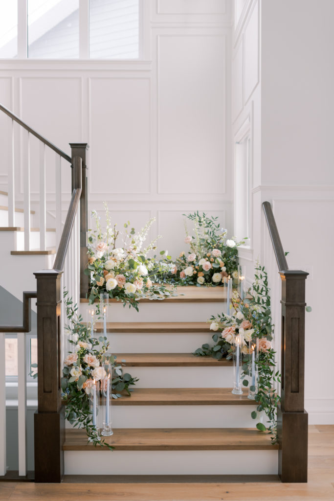 a staircase filled with romantic floral arrangements for a Kelowna estate wedding ceremony 