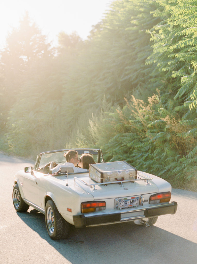 a couple kiss in a convertible 