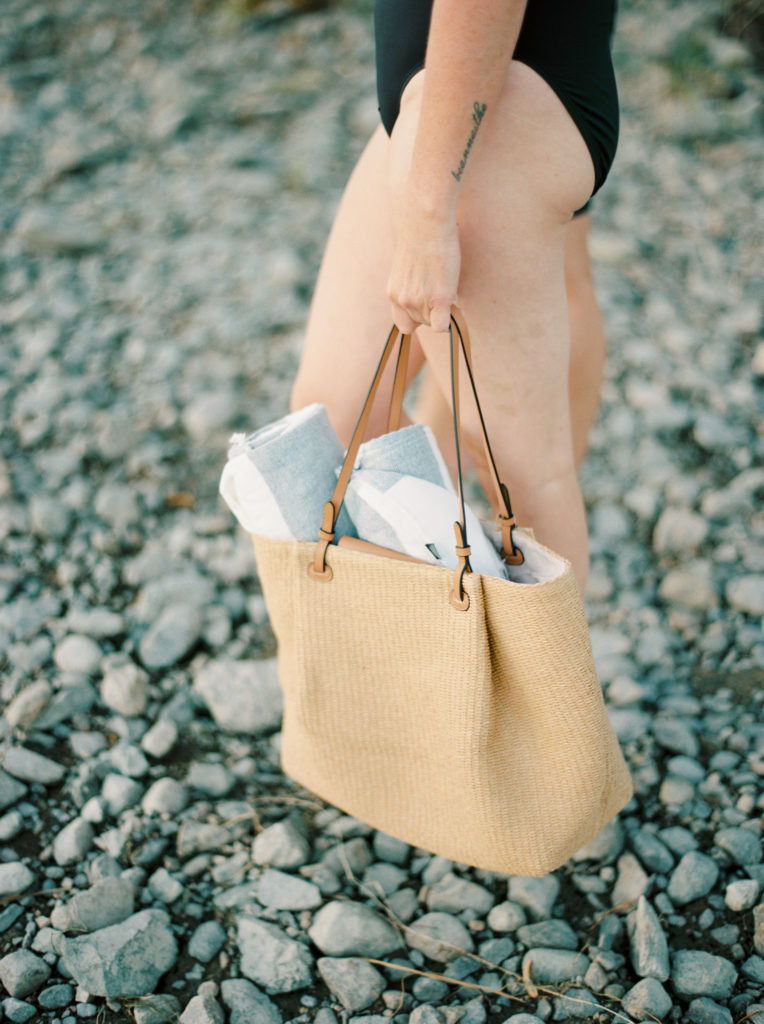a woman holds a beach bag at Okanagan lake 