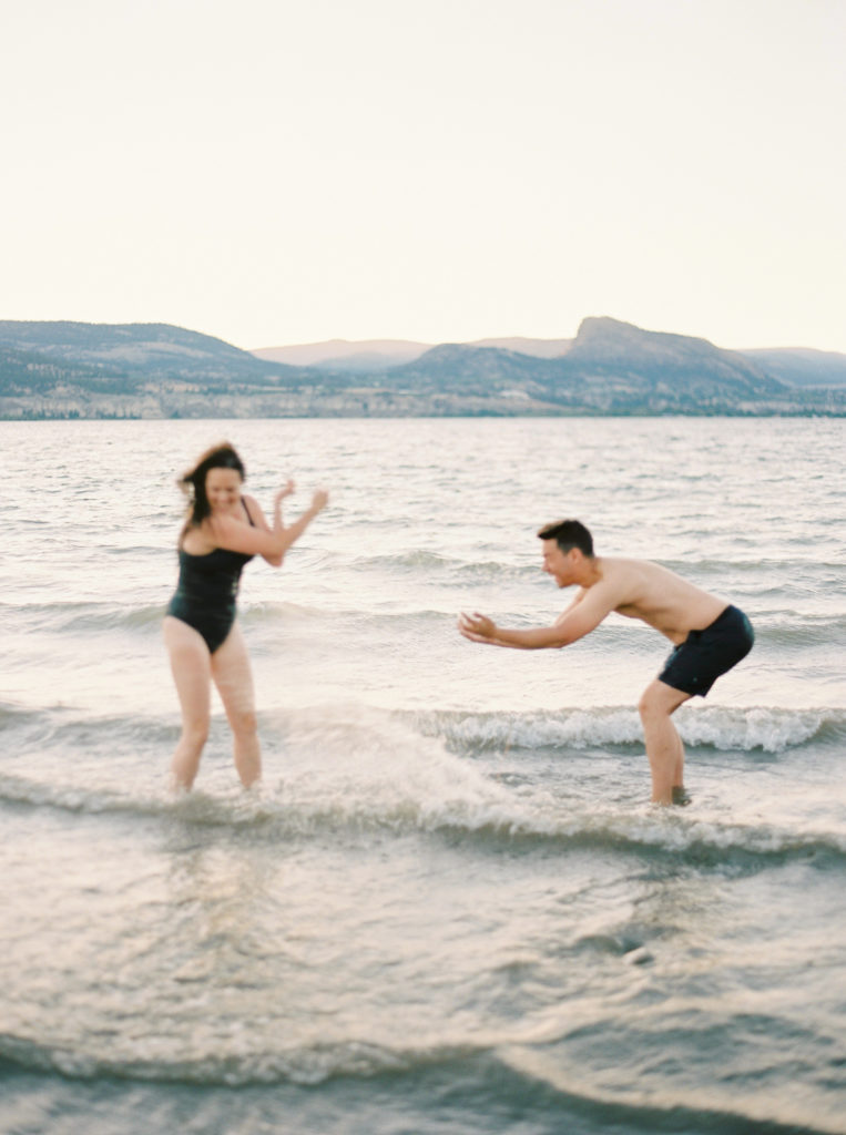 a couple splash in the lake for their Okanagan couples session 